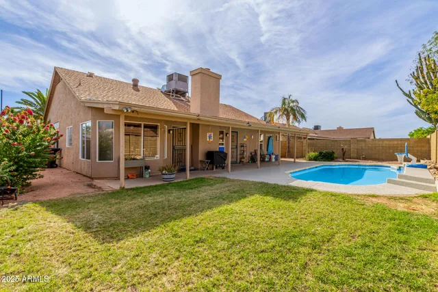 a view of a house with pool and chairs