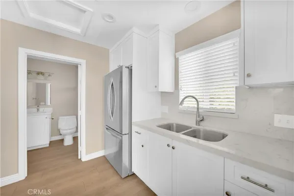 a kitchen with stainless steel appliances granite countertop a sink and a refrigerator