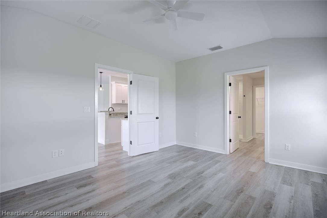 111 Vale Court Sebring, FL 33876 - Photo 19 of 40 an empty room with wooden floor and white doors