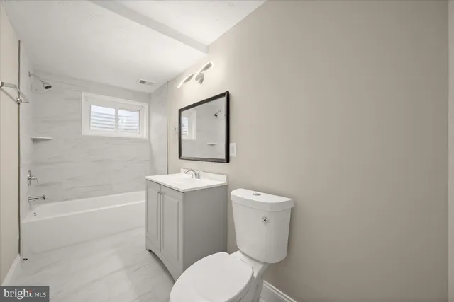 a white toilet sitting next to a bath tub