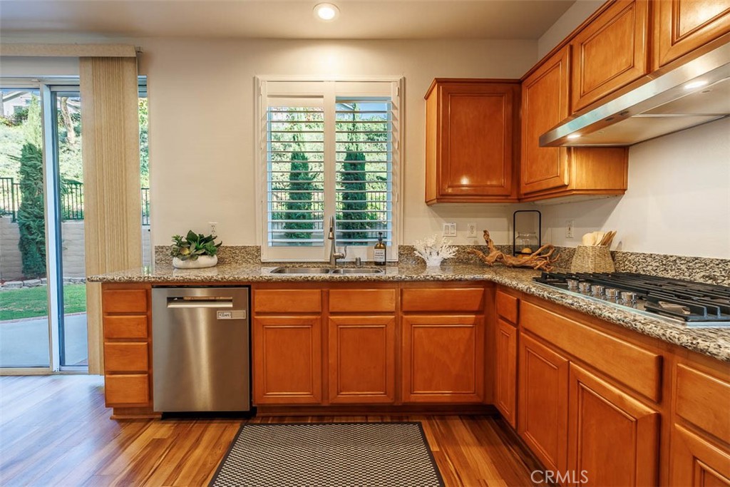 41 Castletree Rancho Santa Margarita, CA 92688 - Photo 21 of 68 a kitchen with stainless steel appliances granite countertop wooden cabinets a sink and a stove
