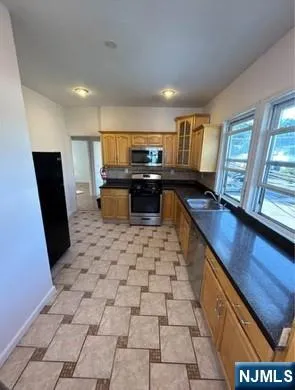 a kitchen with granite countertop a stove a sink a window and a counter top space