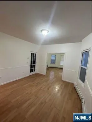 an empty room with a wooden floor and windows