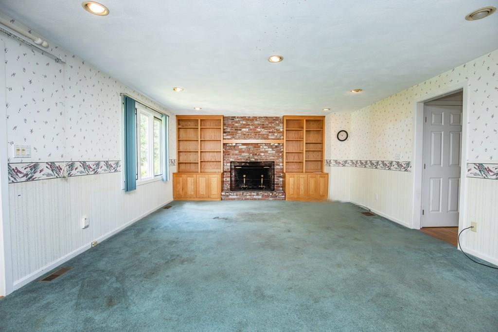 15 Arrowhead Farm Road Boxford, MA 01921 - Photo 6 of 25 an empty room with fireplace and a window