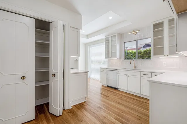 a kitchen with a sink cabinets stainless steel appliances and windows