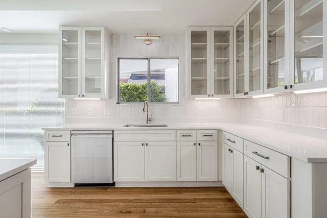 a kitchen with stainless steel appliances white cabinets and a large window