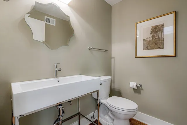 a bathroom with a toilet a sink and mirror