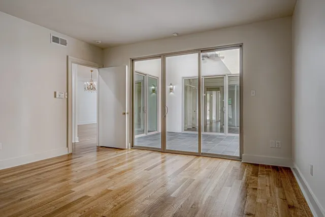 an empty room with wooden floor and door