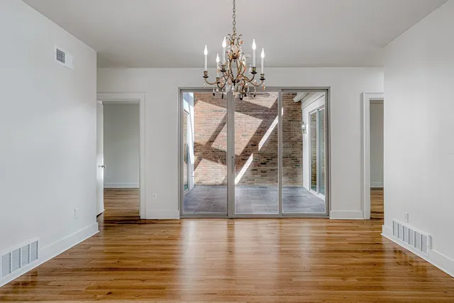 a view of a room with wooden floor staircase and a chandelier