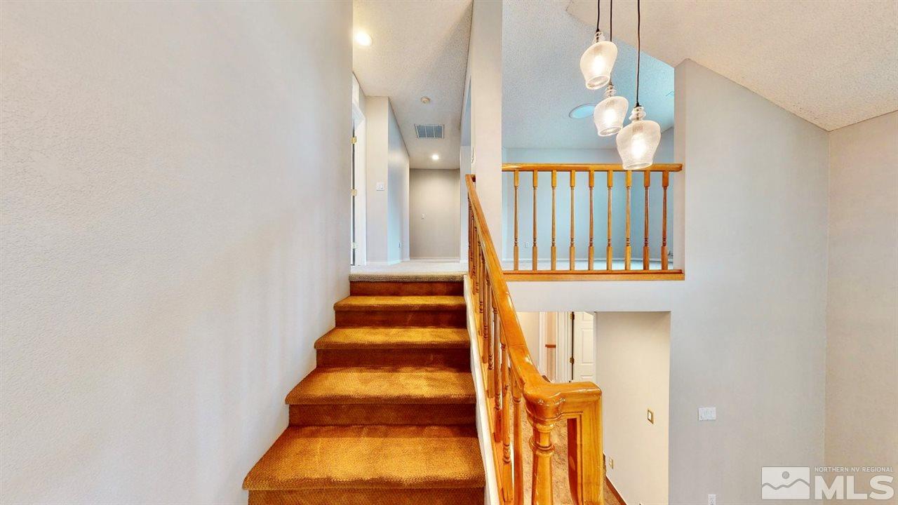 5380 Simons Drive Reno, NV 89523 - Photo 14 of 34 a view of staircase with railing and a chandelier