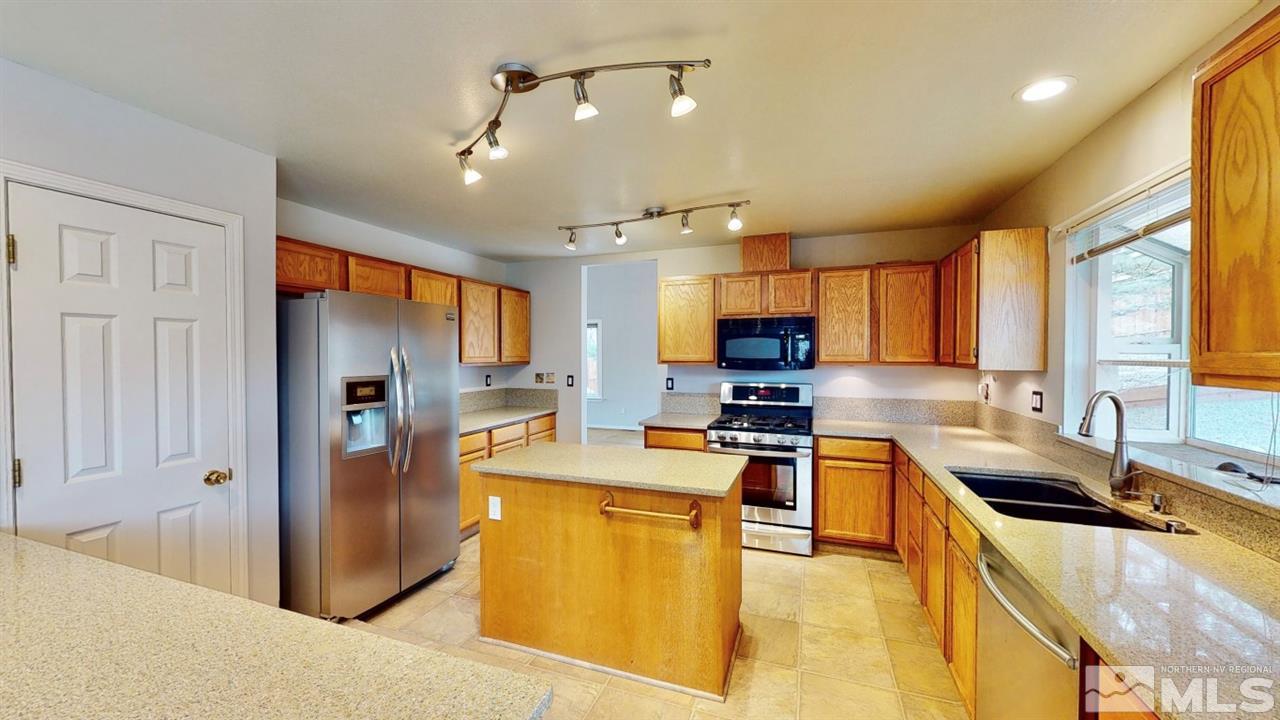 5380 Simons Drive Reno, NV 89523 - Photo 6 of 34 a kitchen with stainless steel appliances granite countertop a sink refrigerator and cabinets