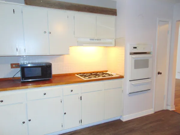 a kitchen with granite countertop white cabinets and a stove