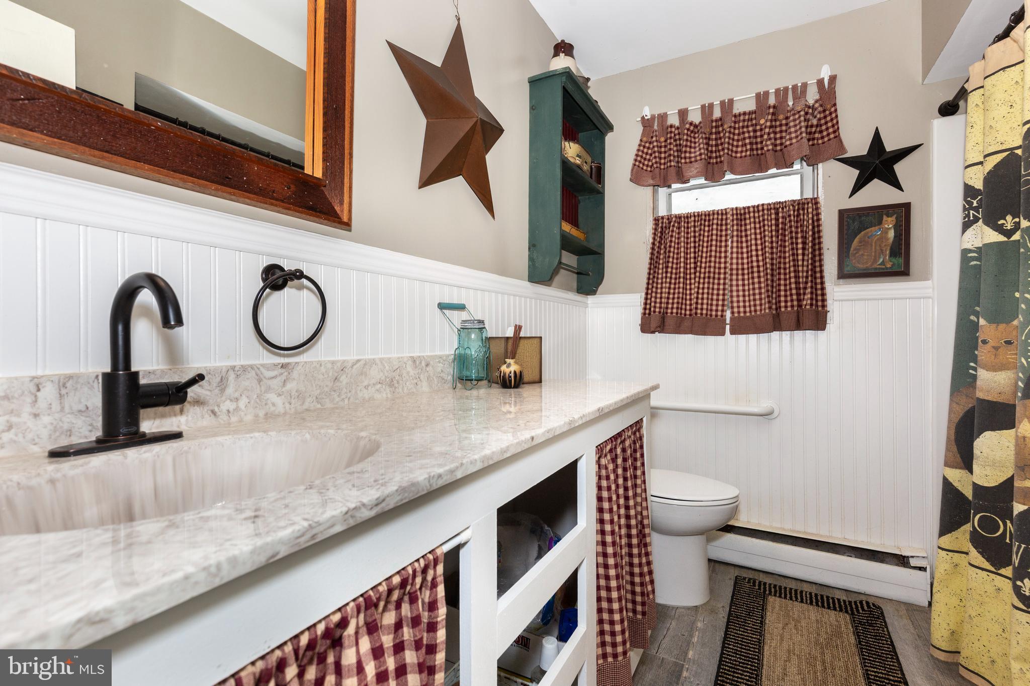 804 William Avenue Westminster, MD 21157 - Photo 11 of 20 a kitchen with a sink and a stove with wooden floor