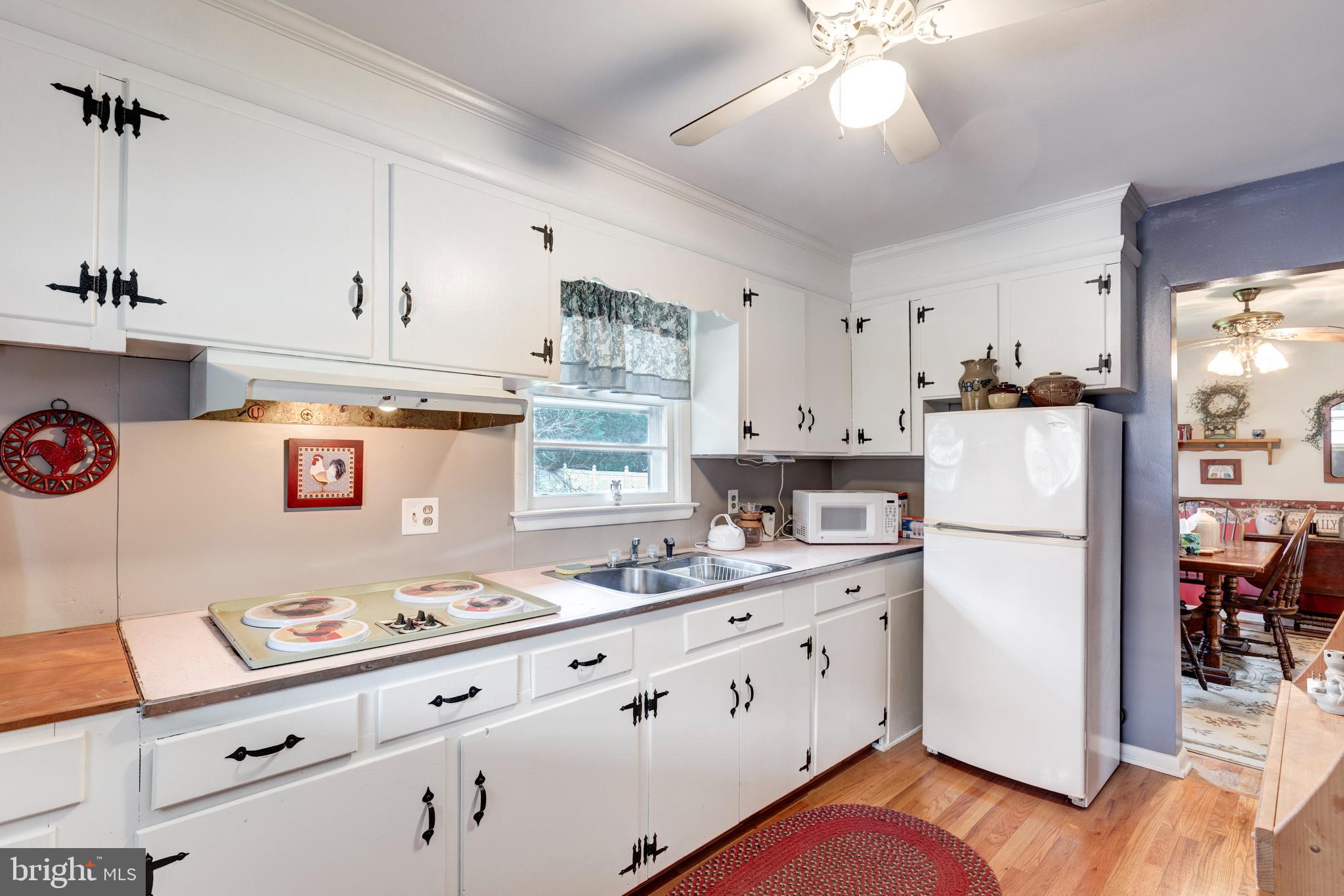 804 William Avenue Westminster, MD 21157 - Photo 7 of 20 a kitchen with granite countertop a refrigerator a stove a sink dishwasher and white cabinets with wooden floor