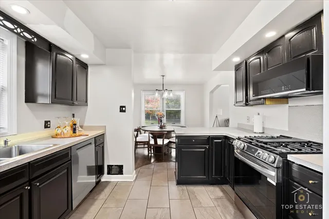 a kitchen with stainless steel appliances a sink stove and microwave