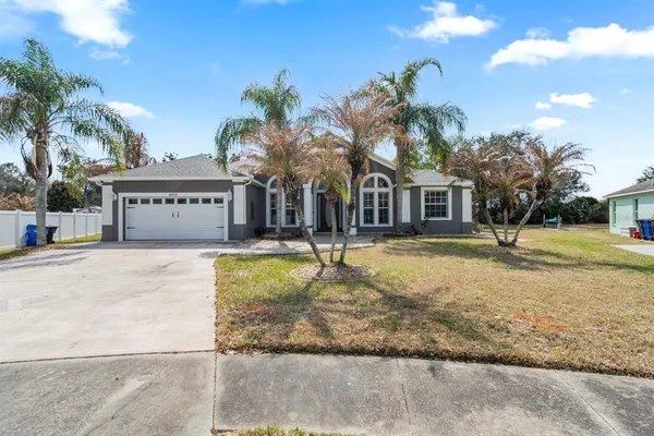 a front view of a building with garden and trees