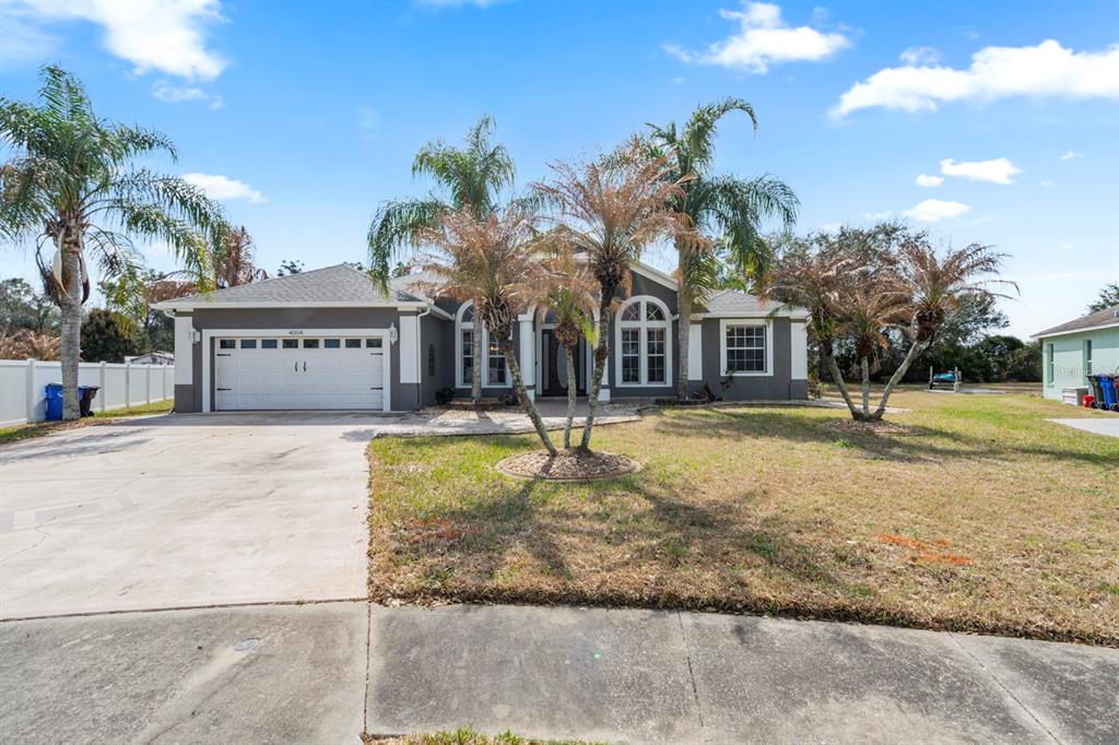 4004 Georgetown Court St. Cloud, FL 34772 - Photo 1 of 1 a front view of a building with garden and trees