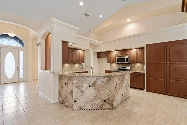 a large kitchen with a refrigerator a stove top oven and a sink