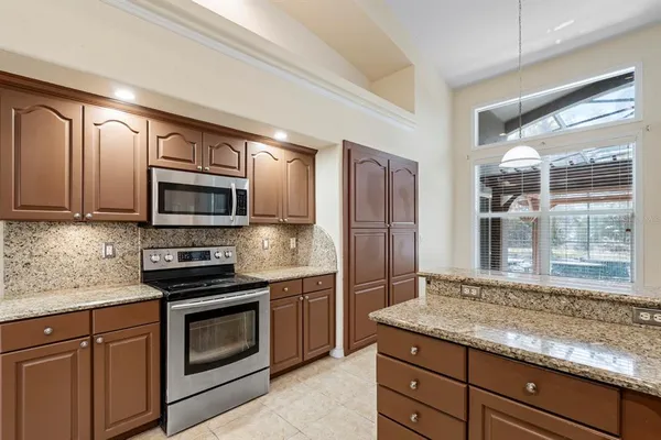 a kitchen with granite countertop cabinets stainless steel appliances and a counter space