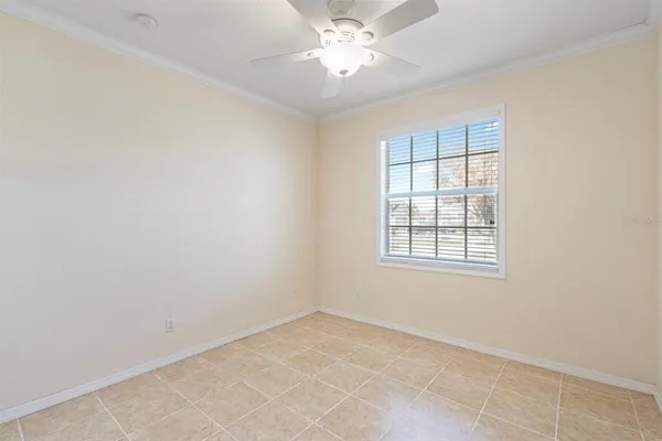 an empty room with a window and a fan