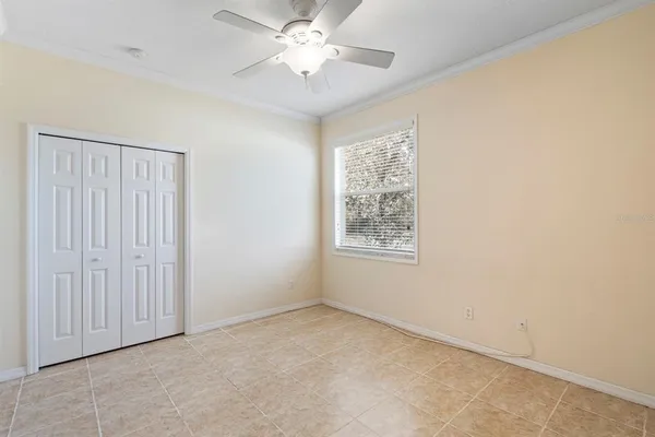 an empty room with windows and fan