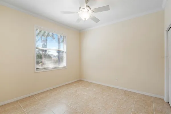 an empty room with a window and a fan