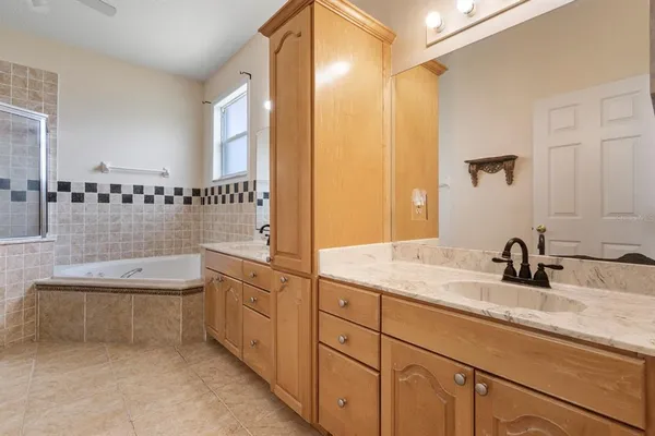 a bathroom with a granite countertop sink a toilet a mirror and bathtub