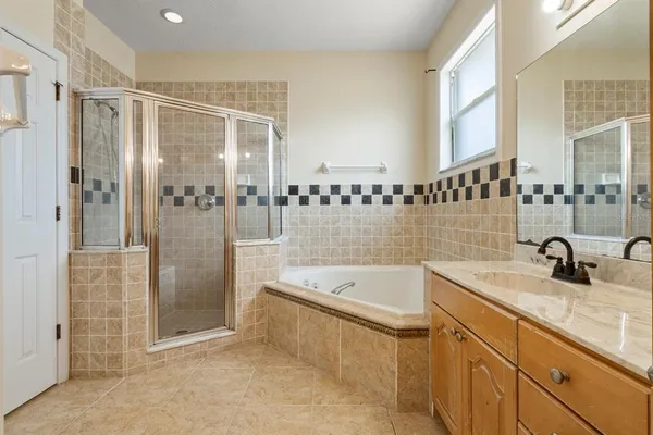 a bathroom with a tub sink and mirror