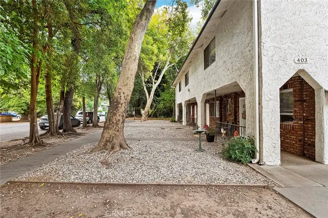 a view of a house with a tree next to a yard