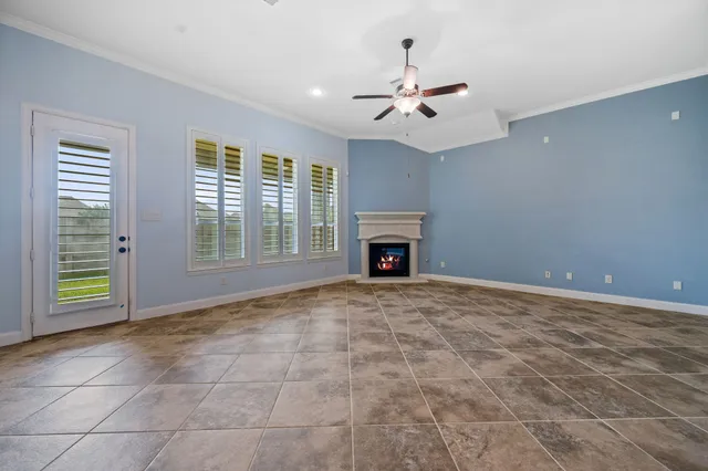 a view of an empty room with kitchen and a window