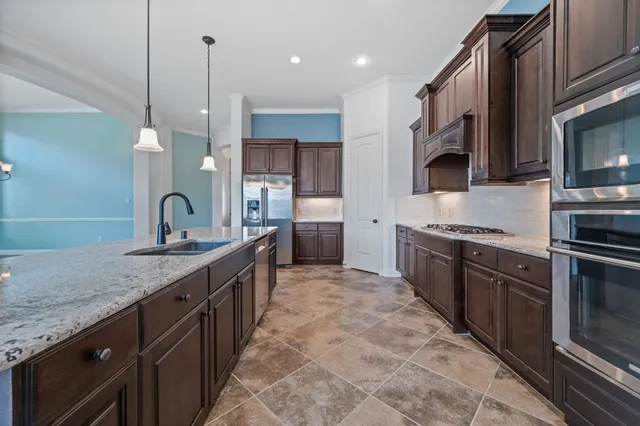 a large kitchen with stainless steel appliances and a sink