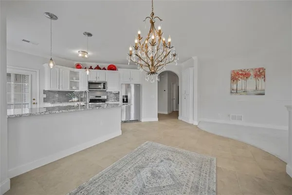 a dining room with furniture a chandelier and wooden floor
