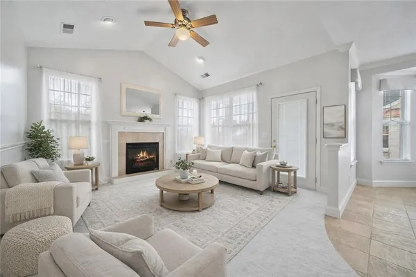 a big room with chandelier fan and windows