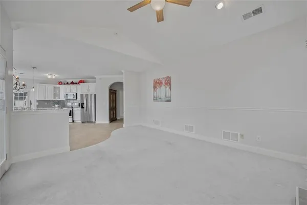 a view of a big room with windows and chandelier fan