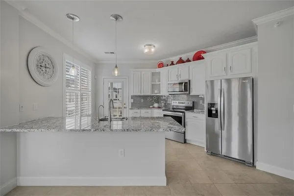 a kitchen with kitchen island granite countertop a sink stainless steel appliances and cabinets