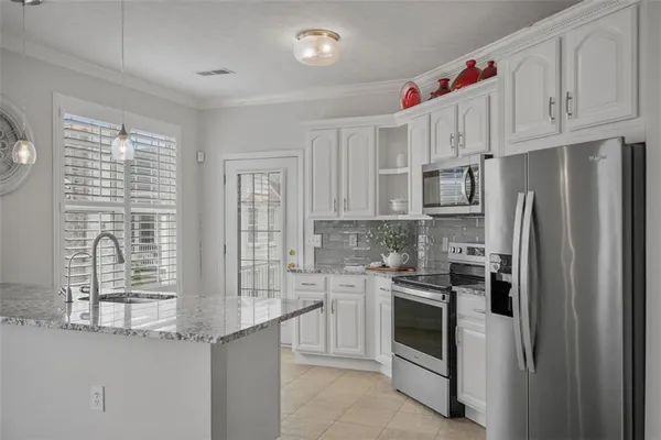a large kitchen with stainless steel appliances granite countertop a lot of counter space and wooden floors