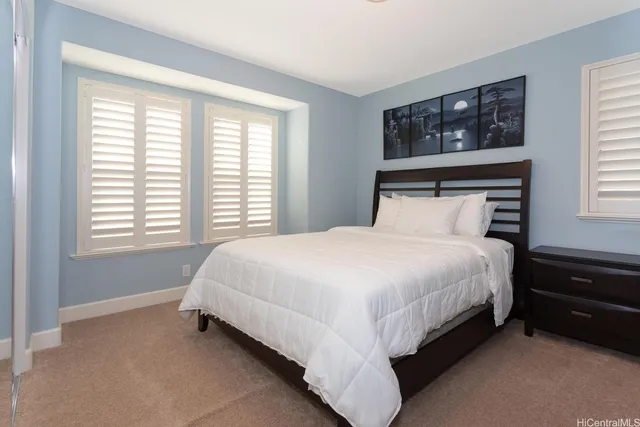 a large bed sitting in a bedroom next to a window