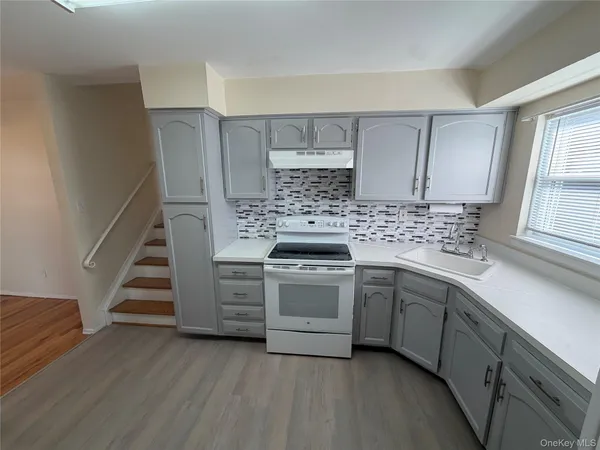 a kitchen with cabinets appliances and a window
