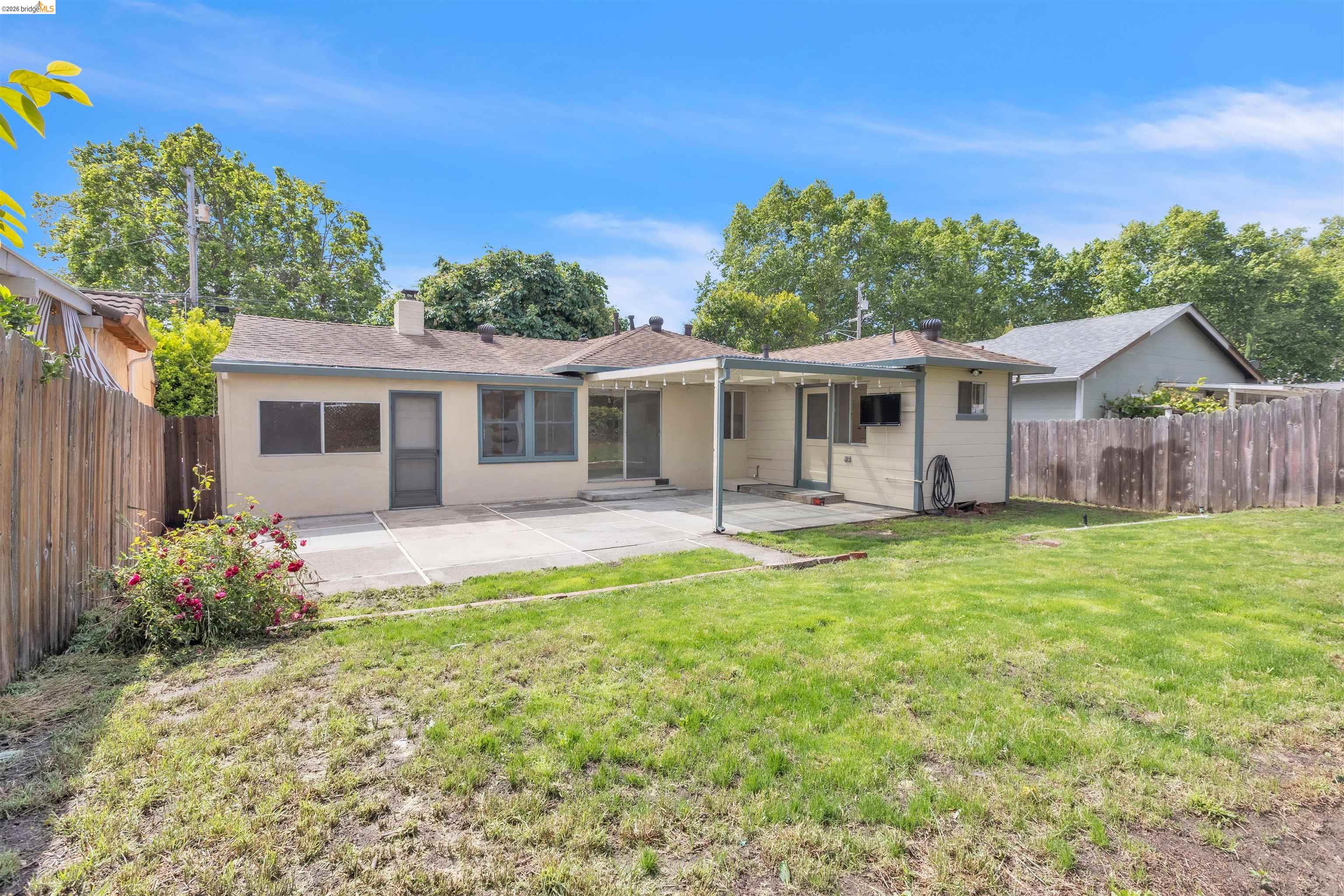 621 Paseo Del Rio San Lorenzo, CA 94580 - Photo 23 of 24 Expansive rear yard featuring a large concrete patio, covered patio area, and mature trees