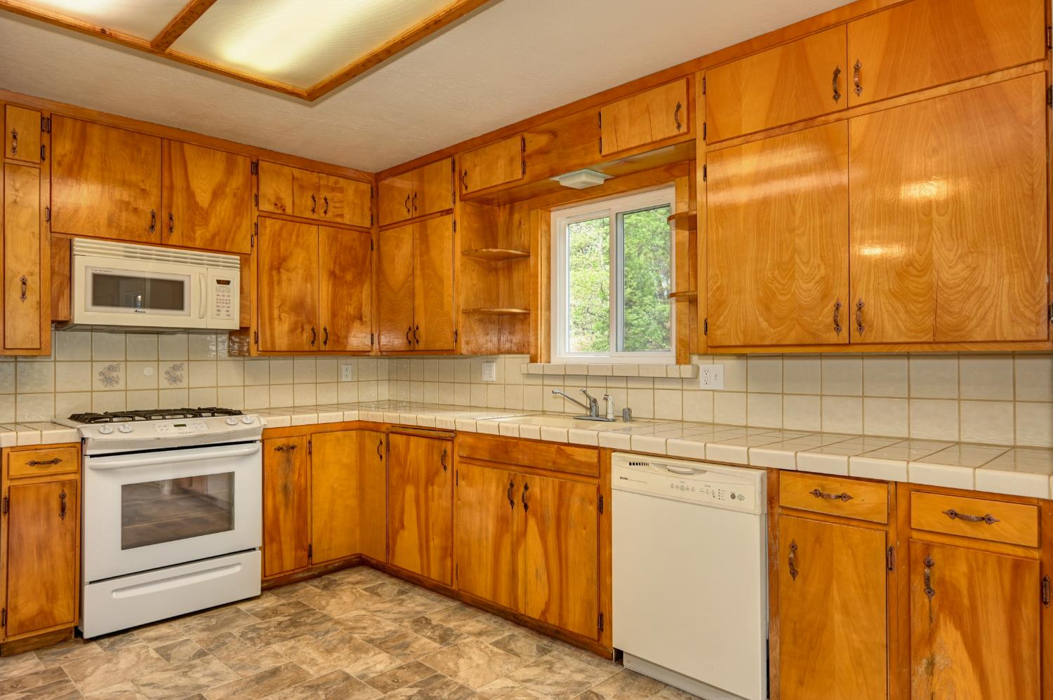 4541 Meadowbrook Road Garden Valley, CA 95633 - Photo 35 of 71 kitchen with tile countertops, white appliances, wood finish cabinetry, and stone finish flooring