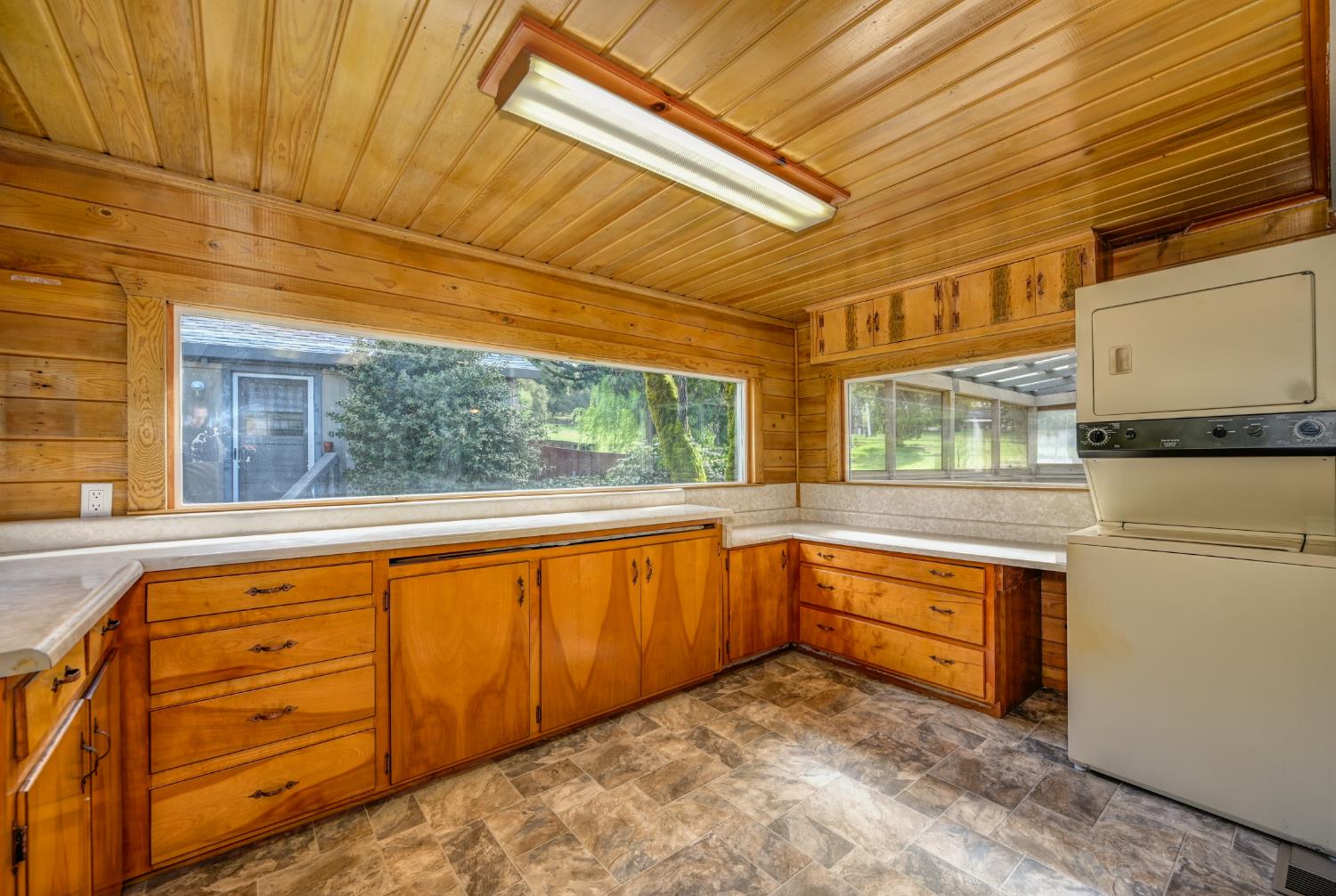 4541 Meadowbrook Road Garden Valley, CA 95633 - Photo 36 of 71 kitchen with stone finish flooring, light countertops, wood finish cabinets, wood ceiling, and wooden walls