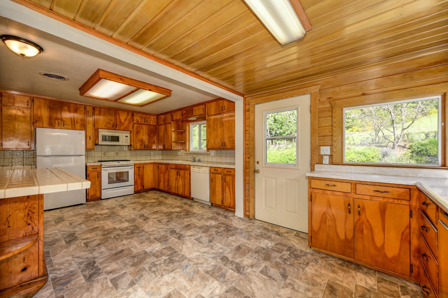 4541 Meadowbrook Road Garden Valley, CA 95633 - Photo 38 of 71 kitchen featuring stone finish floors, wood finish cabinets, white appliances, tile countertops, and wood ceiling
