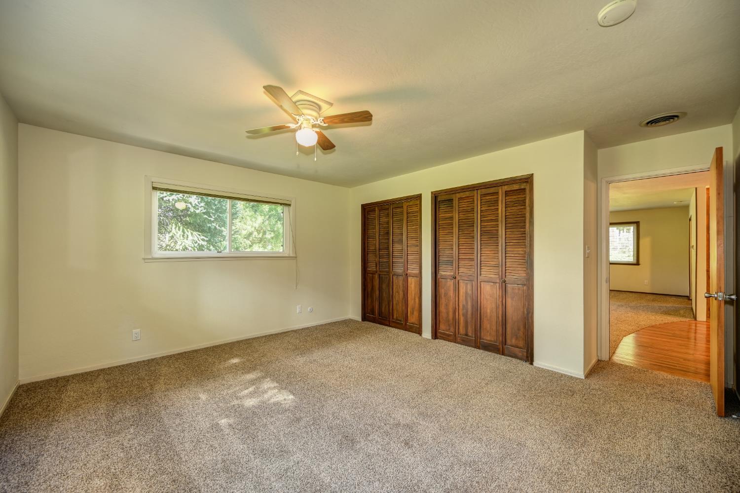 4541 Meadowbrook Road Garden Valley, CA 95633 - Photo 48 of 71 unfurnished bedroom with carpet floors, multiple closets, and a ceiling fan