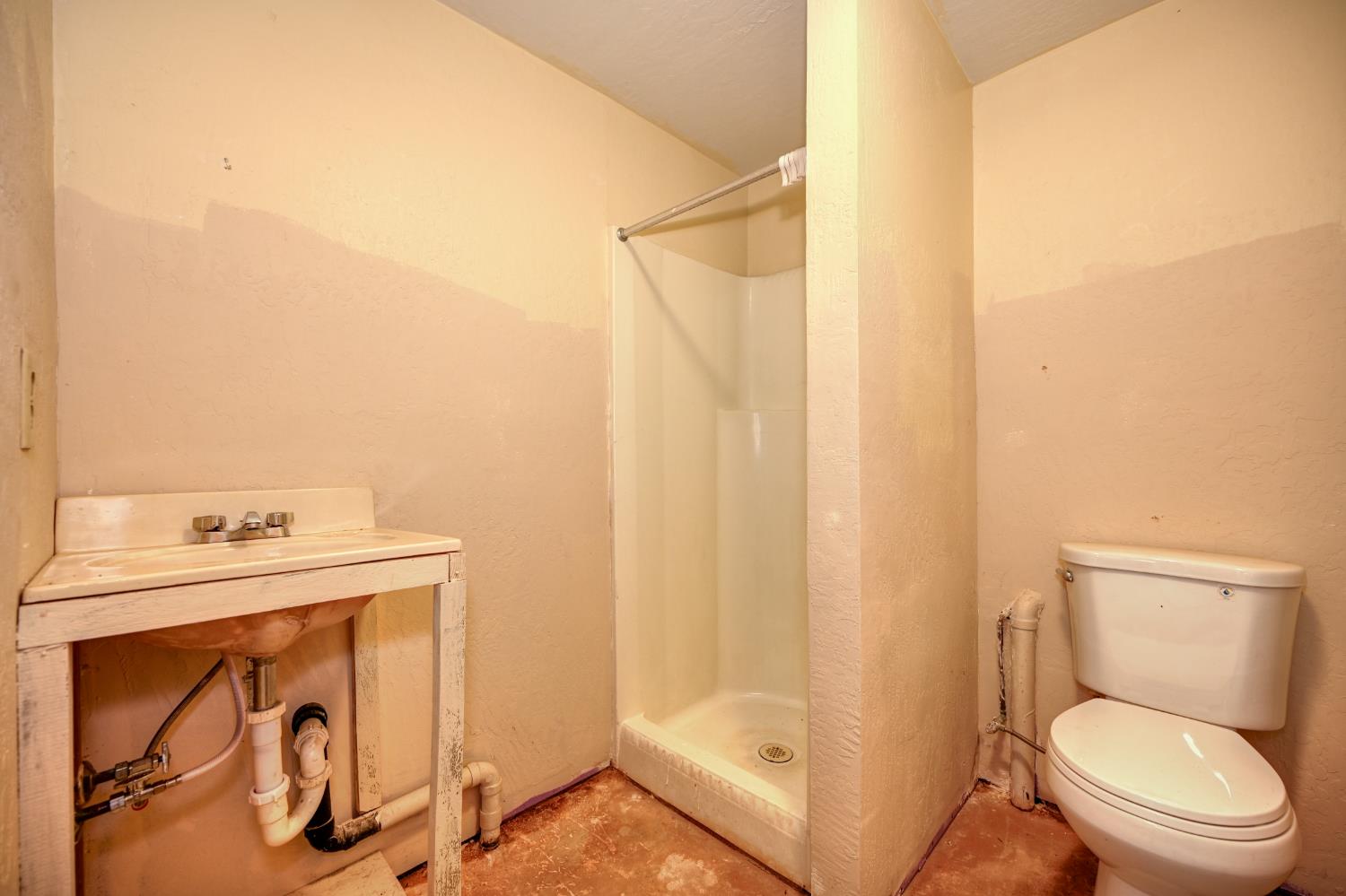 4541 Meadowbrook Road Garden Valley, CA 95633 - Photo 59 of 71 bathroom featuring concrete flooring, a stall shower, and a textured wall