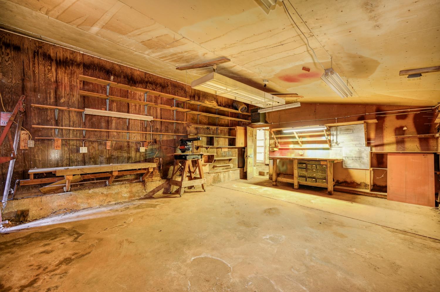 4541 Meadowbrook Road Garden Valley, CA 95633 - Photo 66 of 71 misc room featuring a workshop area, unfinished concrete floors, vaulted ceiling, and wood walls