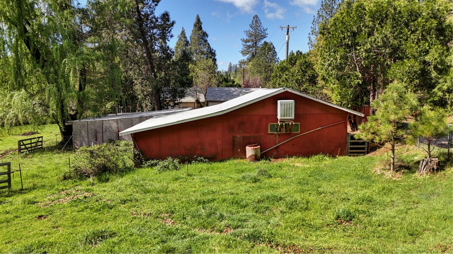 4541 Meadowbrook Road Garden Valley, CA 95633 - Photo 10 of 71 view of home's exterior with an outdoor structure, view of scattered trees, and a pole building