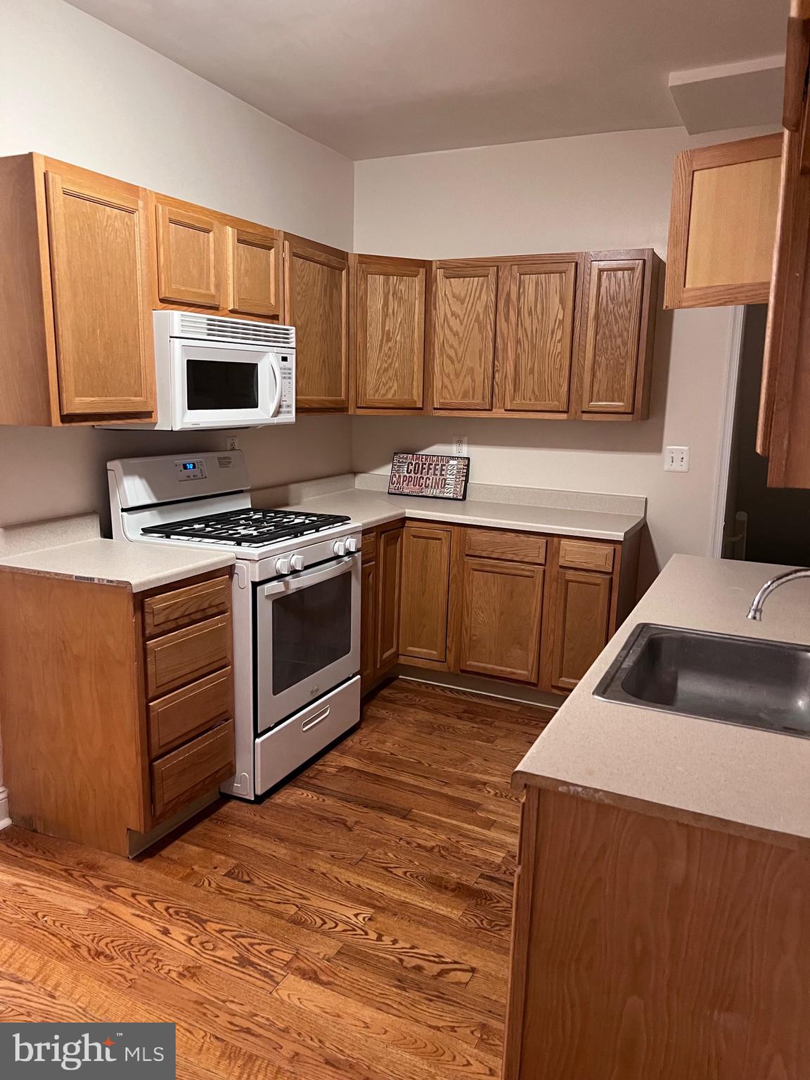 1634 Chilton Street Baltimore, MD 21218 - Photo 6 of 18 a kitchen with stainless steel appliances granite countertop a stove a sink and a microwave
