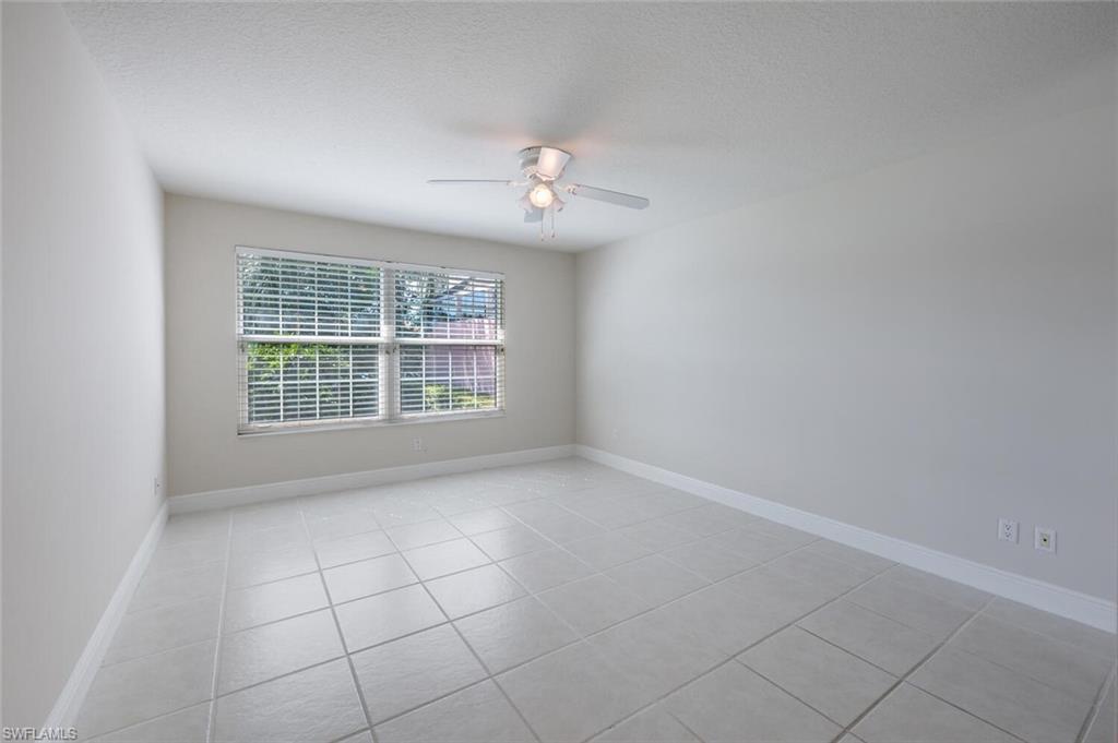 4231 Redonda Lane Naples, FL 34119 - Photo 12 of 28 an empty room with windows and ceiling fan