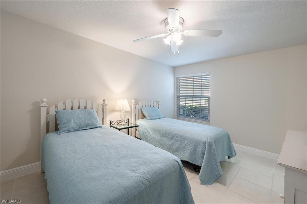 4231 Redonda Lane Naples, FL 34119 - Photo 16 of 28 a bedroom with two beds and a chandelier