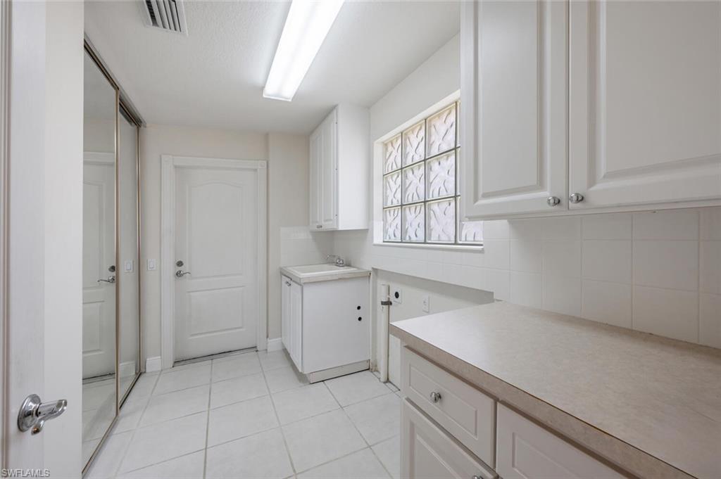 4231 Redonda Lane Naples, FL 34119 - Photo 17 of 28 a room with white cabinets and sink